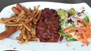 energetic brunch plate with beans, vegan sausages, fried potatoes and salad at Restaurante Vegano Tierra Madre in Valencia