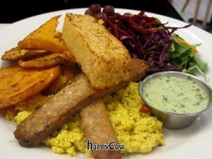 Brunch Le Complet : tofu scramble, tempeh bacon, cornbread, fresh fruit, salad and sweet potatoes. at Aux Vivres - St Laurent in Montreal