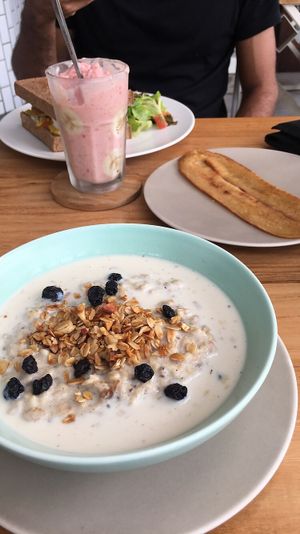 Porridge, side of fake bacon, Flamingo Smoothie and a sandwich with fake ham, cheese and Mayo  at I Am Vegan Babe in Canggu