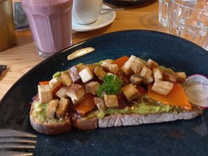 Made up toast with avo, smoked tofu, caramelized onion and pumpkin, try it! at Fauna & Flora in Lisbon