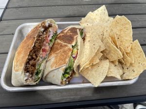 Photo of the anti-gyro wrap with the usual side of tortilla chips.    at Leguminati Vegan Eatery in Orlando