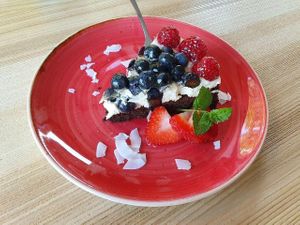 deeply chocolatey vegan cake with cream and fruit at Strh Cafe & Gallery in Zakopane