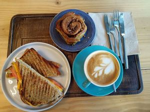 Cheese & tomato toasty, cinnamon bun & coffee with oat milk. at Macaroca in Porto