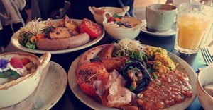2x Full english Breakfast 1x Fruit Salad (left) 1× Oatmeal (top) Hot chocolate and delicious orange juice at Unity Diner in East London