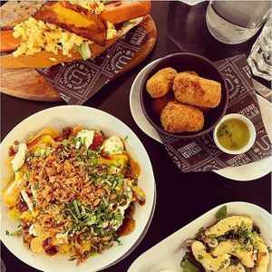 Moving Mountains hotdog with facon and mac'n'cheez, 'mozzerella' dippers, fully loaded fries, tempura prawns at Unity Diner in East London