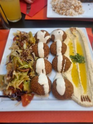 Falafel with hummus and salad, garnished with tahini sauce at Middle East in Como