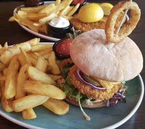 Onion burger in the front and natural Schnitzel with fries and three sauces in the back.  at Apple & Eve in Hamburg