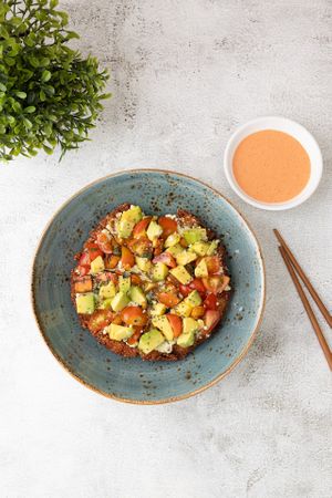 Sushi pizza vegana, base de arroz crujiente, crema de tofu, plátano maduro, aguacate, tomate cherry, mayonesa de pimentón o mayonesa coreana y semillas de sesamo at Come Saludable in La Chorrera