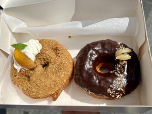 May’s vegan doughnuts: a peachy one and a chocolate one   at Perk Cafe in Inverness