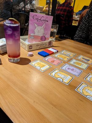 Lavender mocktail with cat lady game at Snakes & Lattes - Bloor St in Toronto