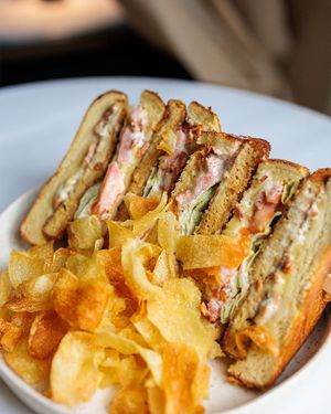 Crispy clubhouse sandwich with brioche bread, tofu, bacon, lemon mayo, potato chips at Avit in Athens
