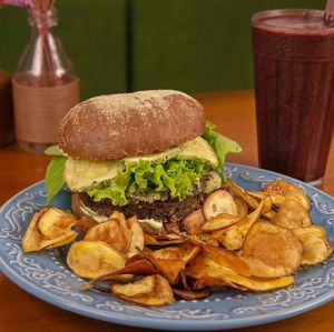 Hambúrguer de cogumelos, com abobrinha grelhada, maionese vegana e alface no pão australiano e acompanha chips de batata doce at Frutaria Pitaya in Sao Paulo