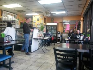 Table and glass case with togo items like sticky rice and beans wrapped in banana leaves, their all vegan. at Veggie Life Restaurant in South El Monte