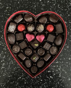 Vegan Silver Embossed Heart - 29 pc (16 oz). Includes includes soft creams, crunchy hazelnut selections, brasero and hazelnut ganaches, marzipan, cordial cherries, & more. at Rose City Chocolatier in Martinsburg