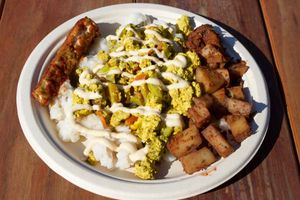 Tofu scramble served over rice (choice of rice or mixed greens) with soy free tempeh bacon, seasoned potatoes, and cashew cheese. at The Peaceful Palate in Eugene