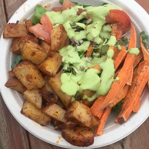 Salad served with seasoned potatoes and baked sweet potato fries at The Peaceful Palate in Eugene