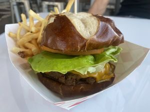 Cheeseburger on pretzel bun with fries  at Veggy Street in Henderson
