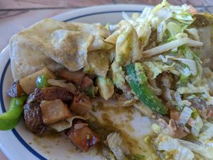 It was filled with potatoes, refried beans, avocado, onion, green pepper, and topped with tomatillo, lettuce, and tomatoes. at Adriana's in Cottonwood