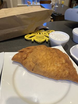 Panzerotti takeout. Hard to see size but it’s just about smaller but close to football sized.   at Amico's Pizza in Toronto
