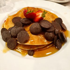 Vegan pancakes with dark chocolate drops, strawverries, and maple syroup at POG - Tara St in Dublin