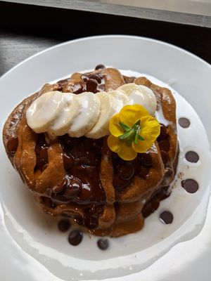Vegan protein pancakes with almond butter, banana, coconut cream and maple syrup at POG - Tara St in Dublin