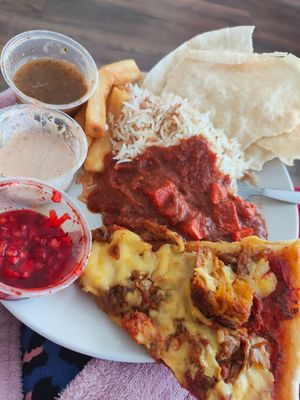 Tofu tikka masala, garlic rice, slice of seitan bhuna pizza, chips, poppadoms and dips at Karma Kitchen Cafe in Newcastle Upon Tyne