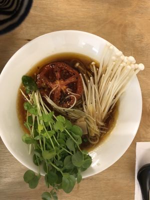 Mushroom based broth, topped with enoki and braised tomato at Vegan Ramen Shop - Mokotów in Warsaw