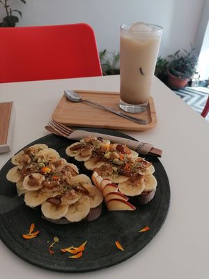 Iced Chai latte. Toast tahini, banana, dates, walnut at Parcería - Culto Al Cafè in Sevilla