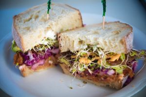 100% plant-based BBQ pulled pork sandwich with organic and local avocados, alfalfa sprouts, rainbow coleslaw, vegan bacon and cheeze. Delicious! at Earth Aloha Eats - Waikiki in Honolulu
