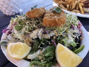 Vegan Golden Fish Salad with organic mixed greens, rainbow coleslaw, onions, tomatoes, sprouts, crushed peanuts, lemon wedges and house-made tartar sauce.  at Earth Aloha Eats - Waikiki in Honolulu