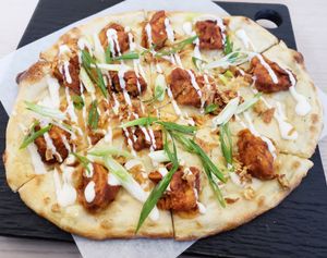 Stranger Wings pizza, made with spicy buffalo cauliflower, fried shallots, blue cheese drizzle, and scallions. at Virtuous Pie in Toronto