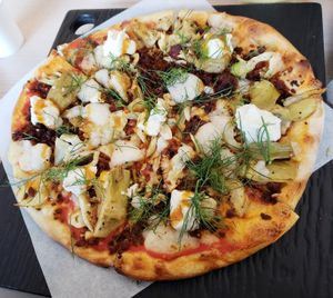Chorizo artichoke pizza w/ San Marzano tomato sauce, spicy chorizo, cashew mozzarella cheese, roasted artichokes and fennel, plant-based honey, lemon almond ricotta, and fresh dill at Virtuous Pie in Toronto