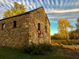 The golden hues of autumn grace the peaceful farm building. at Ron Weiss MD - Ethos Farm Project in Washington Township