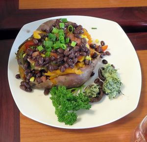 Sweet potato slow roasted then smashed and smothered with house spiced organic black beans, sweet corn, wilted spinach with roasted garlic & chopped roasted red peppers. at Kelley Farm Kitchen in Harpers Ferry