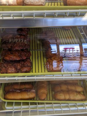 Awesomely apple fritters, in dessert case with cinnamon rolls at Vegan Donut-Gelato in Houston
