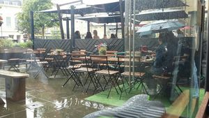Eating in the rain. Parosols or a gazebo are needed! at Roots & Shoots Cafe in Bath