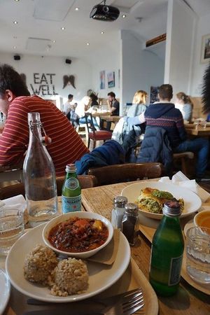 Fire place under "EAT WELL" sign.  Spacious cozy eat-in room. at The Happy Pear in Greystones