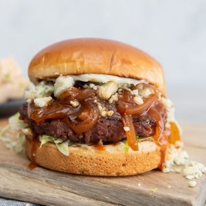 Steakhouse Burger: Impossible ™ burger, caramelized onion sauce, blue cheese crumbles, iceberg lettuce, and horseradish aioli served on a brioche bun at Veggie Grill by Next Level - UCLA Ackerman Union in West Los Angeles