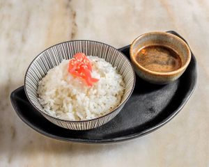 Taça de arroz japonês cozido ao vapor, guarnecido com sementes de sesamo e gengibre marinado. at Koppu Ramen Izakaya in Lisbon