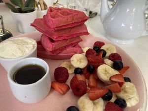 Pink waffles with fruits, whipped cream and maple syrup   at Naked Bakery in Edinburgh