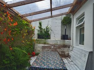 Outside covered seating area with open toilet window at Antiquity Plant-based Cafe @ The Timetravellers Bookshop in Skibbereen