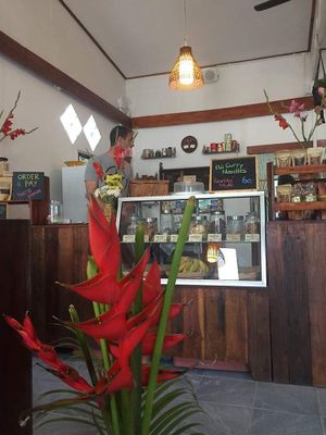 Beautiful flowers give the restaurant a lovely atmosphere with a cabinet full of lovely home baked biscuit  at Ganita Cafe in Pai