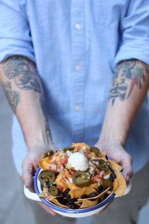 Gallo Santo’s famous Nachos include corn tortilla chips, jalapeños, “Pico de Gallo’, soy cream, black beans and potatoe-carrot cheese. at Gallo Santo in Barcelona