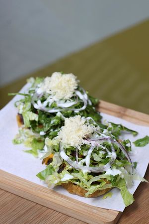 Pumpkin Flower Sopes with black beans “Frijoles”, red onion, sour soy cream, coconut cheese, lettuce and sweet “Chile Pasilla” sauce. at Gallo Santo in Barcelona