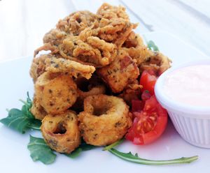 Calimari vegani - Hearts of palm “calamari” seasoned with nori powder & old bay spices, battered in
chickpea our and deepfried. at Fishes & More in Palm Beach