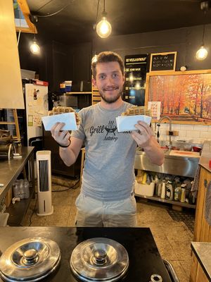 Owner's son with hot fresh waffles   at VeganWaf in Brussels