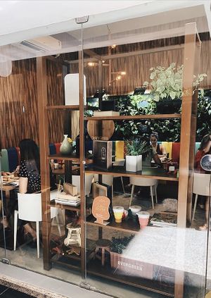 Dentro de galeria. Tem dois espaços frente a frente. Ambos com mesas e cadeiras confortáveis  at Manu Tenório Café in Recife