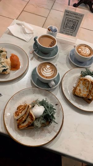 Avocado toast with halloumi (centre & right), eggs royal (left) + two cappuccinos and an orange hot chocolate.  at The Flower Cup in Chester