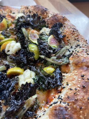 Lemon Purple Kale, figs, vegan mozzarella and sesame crust pizza. at Tribute Pizza in San Diego