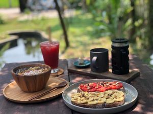 Smoothie bowl of red dragon fruit, toast with homemade nut butters, juices and french press coffee. at Nourish in Hoi An